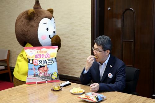 ポテトチップス辛麺味を試食する知事の写真